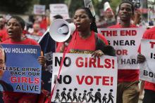 People hold placards calling for the release of secondary school girls abducted in the remote village of Chibok, during a protest along a road in Lagos