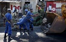 A policeman throws a stone as he clears a barricade which was set up by protesters in Bujumbura, Burundi, May 10. 2015. PHOTO BY REUTERS/Goran Tomasevic