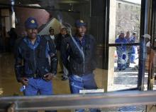 Police officers are reflected in a damaged window after students clashed with security at University of the Witwatersrand as countrywide protests demanding free tertiary education entered a third week, Johannesburg, South Africa, September 20, 2016. PHOTO BY REUTERS/Siphiwe Sibeko