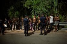 Police stand around a group of African migrants after they crossed the border fence from Morocco to Spain's North African enclave of Ceuta, Spain, early August 7, 2017. PHOTO BY REUTERS/Jesus Moron