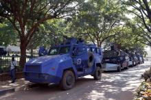 A man walks past police crowd control armored vehicles parked in Uganda's capital Kampala February 17, 2016, a day ahead of the presidential election. PHOTO BY REUTERS/James Akena