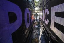 A Thai security personnel inspects destroyed police trucks at the Thai-Japan youth stadium, the site of fierce clashes between anti-government protester and riot police, in central Bangkok