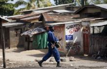 A policeman shouts as he prepares to throw a teargas canister during a protest against Burundi President Pierre Nkurunziza and his bid for a third term in Bujumbura, Burundi, June 2, 2015. PHOTO BY REUTERS/Goran Tomasevic