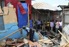 Somali policeman shifts through debris after a blast occurred at a government tax collection point near Kaaraan district, north of Mogadishu 