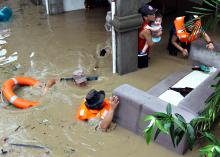 Policemen evacuate families trapped in their home during heavy flooding brought by tropical storm Seniang in Misamis Oriental, Mindanao island in southern Philippines, December 29, 2014. PHOTO BY REUTERS/Erwin Frames