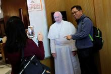 A Catholic poses for a photo with a cardboard cutout of Pope Francis at a church in Taipei, Taiwan, March 11, 2018. PHOTO BY REUTERS/Tyrone Siu