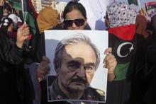 A woman holds a portrait of former Libyan army officer Khalifa Haftar, during a rally supporting Haftar, in Benghazi