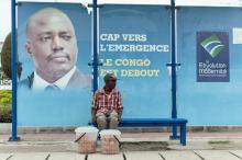 A vendor sits at a bus stand with pictures of President Joseph Kabila in Kinshasa, Democratic Republic of Congo, December 31, 2016. PHOTO BY REUTERS/Robert Carrubba