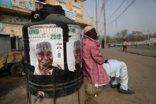 A man sits next to a campaign poster of Atiku Abubakar, leader of the People's Democratic Party (PDP), after the postponement of the presidential election in Kano, Nigeria, February 17, 2019. PHOTO BY REUTERS/Luc Gnago