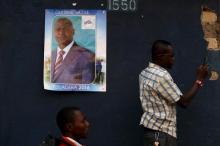 Supporters watch traditional dancers next to a poster of Faustin-Archange Touadera, who will be ruining against Anicet-Georges Dologuele in Sunday's second round of presidential election, during a campaign in the mostly muslim PK5 neighbourhood of the capital Bangui, Central African Republic, February 10, 2016. PHOTO BY REUTERS/Siegfried Modola