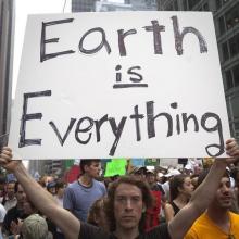 A protester carries a sign during the "People's Climate March" in the Manhattan borough of New York, September 21, 2014. PHOTO BY REUTERS/Carlo Allegri