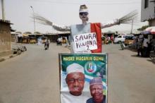 A dummy made out of sticks of a broom, the All Progressives Congress (APC) party's symbol, is placed next to an election poster campaigning for APC's presidential candidate Muhammadu Buhari, along a road in Katsina city, March 26, 2015. PHOTO BY REUTERS/Akintunde Akinleye