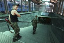 Armed pro-Russian separatists walk down a flight of stairs at a railway station in Donetsk