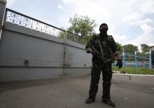 A pro-Russian separatist stands guard near the gates of a base in the east Ukrainian city of Donetsk