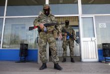 Pro-Russia armed men stand guard in front of the seized city council building in Kostyantynivka