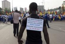 A man wears a sign on his back with his request to be trained and sent to the front line to fight against the Boko Haram attends a march in support of the Cameroonian army in Yaounde, February 28, 2015. PHOTO BY  REUTERS/Bate Felix