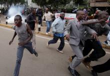 Supporters of Kenya's opposition Coalition for Reforms and Democracy (CORD) run away after riot police lobbed teargas canisters to disperse them during a protest at the premises hosting the headquarters of Independent Electoral and Boundaries Commission (IEBC) to demand the disbandment of the electoral body ahead of next year's election in Nairobi, Kenya, May 23, 2016. PHOTO BY REUTERS/Goran Tomasevic