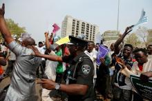 A Nigerian police officer tries to disperse protesters, some supporting and some opposing the suspension of the Chief Justice of Nigeria (CJN) Walter Onnoghen, in Abuja, Nigeria, January 28, 2019. PHOT BY REUTERS/Afolabi Sotunde