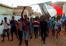 Sudanese protesters chant slogans and wave their national flag as they demonstrate against the ruling military council. PHOTO BY REUTERS/Mohamed Nureldin Abdallah