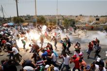 Palestinians react following tear gas that was shot by Israeli forces after Friday prayer on a street outside Jerusalem's Old city, July 21, 2017. PHOTO BY REUTERS/Ammar Awad