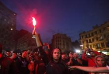 A protester holds a flare during a demonstration against a new law restricting demonstrations, in downtown Cairo