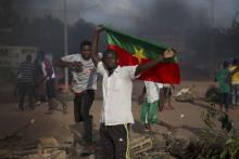 An anti-coup protester holds a Burkinabe flag in Ouagadougou, Burkina Faso, September 18, 2015. Leaders of a coup in Burkina Faso said on Friday they had freed the president and reopened borders, in an apparent olive branch to mediators and protesters who rallied in the capital and other cities against the putsch. PHOTO BY REUTERS/Joe Penney