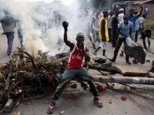 A protester sits in front of a burned barricade during a protest against Burundi President Pierre Nkurunziza and his bid for a third term in Bujumbura, Burundi, May 21, 2015. PHOTO BY REUTERS/Goran Tomasevic