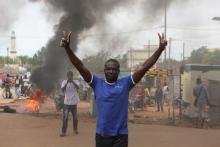 A protester gestures in front of a burning roadblock in Ouagadougou, Burkina Faso, September 18, 2015. PHOTO BY REUTERS/Joe Penney