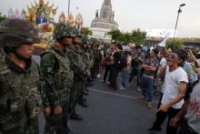 Protesters against military rule face soldiers at the Victory monument in Bangkok