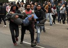 Anti-government protesters help an injured protester when pro-government protesters threw stones during a protest in front of the press syndicate in Cairo, January 25, 2015. PHOTO BY REUTERS/Asmaa Waguih