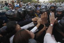 Protesters clash with police officers during a demonstration in central Phnom Penh
