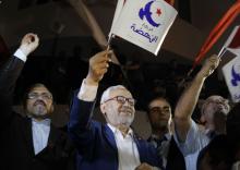 Rached Ghannouchi, leader of the Islamist party Ennahda, waves the party flag outside Ennahda's headquarters in Tunis, October 27, 2014. PHOTO BY REUTERS/Zoubeir Souissi