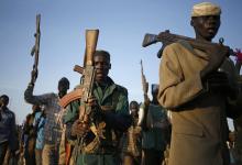 Rebel fighters hold their weapons as they march in a village in the rebel-controlled territory of Upper Nile state