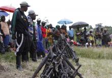 Militants from the Democratic Forces for the Liberation of Rwanda (FDLR) stand near a pile of weapons after their surrender in Kateku, a small town in eastern region of the Democratic Republic of Congo (DRC)