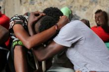 Somali refugees who survived an attack on a boat off Yemen's coast in the Red Sea hug each other as they sit at a detention center in the Houthi-held port of Hodeidah, Yemen, March 22, 2017. PHOTO BY REUTERS/Abduljabbar Zeyad