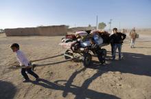 Kurdish Syrian refugees carry their belongings after crossing the Turkish-Syrian border, near the southeastern town of Suruc in Sanliurfa province