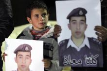 A relative of Jordanian pilot Muath al-Kasaesbeh, who was captured by Islamic State after his plane crashed in northeastern Syria in December during a bombing mission against them, holds a picture of him at the family's headquarters in the city of Karak, January 29, 2015. PHOTO BY REUTERS/Ahmad Abdo