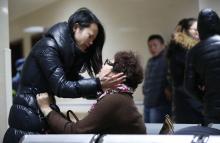 Relatives of a victim hug as they wait at a hospital where injured people of a stampede incident are treated in Shanghai, January 1, 2015. PHOTO BY REUTERS/Aly Song
