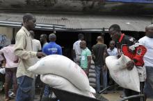 Residents of West Point neighbourhood, which has been quarantined following an outbreak of Ebola, receive food rations from the United Nations World Food Programme (WFP) in Monrovia