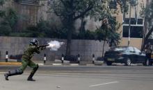 A riot policeman fires a teargas canister to disperse supporters of Kenya's opposition Coalition for Reforms and Democracy (CORD) during a protest at the premises hosting the headquarters of Independent Electoral and Boundaries Commission (IEBC) to demand the disbandment of the electoral body ahead of next year's election in Nairobi, Kenya, May 23, 2016. PHOTO BY REUTERS/Thomas Mukoya