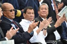 Philippine President Rodrigo Duterte (C), accompanied by Transportation Secretary Arthur Tugade (R) and Defense Secretary Delfin N Lorenzana (L), claps at the end of Japan's coast guard drills in Yokohama, Japan, October 27, 2016. PHOTO BY REUTERS/Kazuhiro Nogi