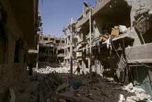 A man walks on rubble of damaged buildings in the besieged town of Douma, Eastern Ghouta, in Damascus, Syria, March 21, 2018. PHOTO BY REUTERS/Bassam Khabieh