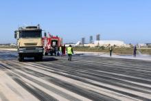 Fire brigade workers clean the runway after an airstrike hit Tripoli's Maitiga airport, March 3, 2015. PHOTO BY REUTERS/Hani Amara