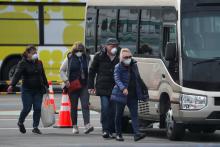 Russian passengers walk with their luggage after leaving the coronavirus-hit Diamond Princess cruise ship docked at Yokohama Port, south of Tokyo, Japan, February 20, 2020. PHOTO BY REUTERS/Kim Kyung-Hoon