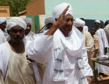 Sudan's former prime minister and opposition politician Sadiq al-Mahdi (R) waves to protesters during a demonstration against the Israeli raids on Lebanon, in Sudan's capital Khartoum