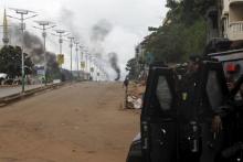 Guinea's security forces are seen as smoke billows on a street in Bambeto during a protest after opposition candidates called on Monday for the results of the election to be scrapped due to fraud, in Conakry, October 13, 2015. PHOTO BY REUTERS/Luc Gnago