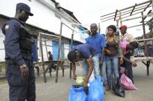 Security forces control a checkpoint outside the Ebola quarantine area of West Point as relatives carry food and essentials for their family members, in Monrovia