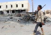 A member of the security team walks past the remains of a burnt car after a suicide car bomber hit a Libyan police station west of the besieged Islamic State stronghold of Sirte, June 16, 2016. PHOTO BY REUTERS/Stringer