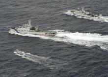 An aerial photo shows Chinese marine surveillance ship Haijian No. 66 (top) trying to approach a Japanese fishing boat (bottom) as Japan Coast Guard vessel Ishigaki cruises next to the Chinese ship, in the East China Sea, near what are known as the Senkaku isles in Japan and the Diaoyu islands in China