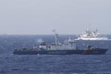 A ship (top) of the Chinese Coast Guard is seen near a ship of the Vietnam Marine Guard in the South China Sea, about 210 km (130 miles) off the shore of Vietnam, May 14, 2014. PHOTO BY REUTERS/Nguyen Minh